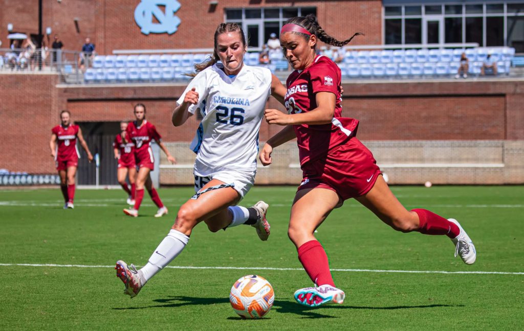 Two soccer players competing for the ball during a match